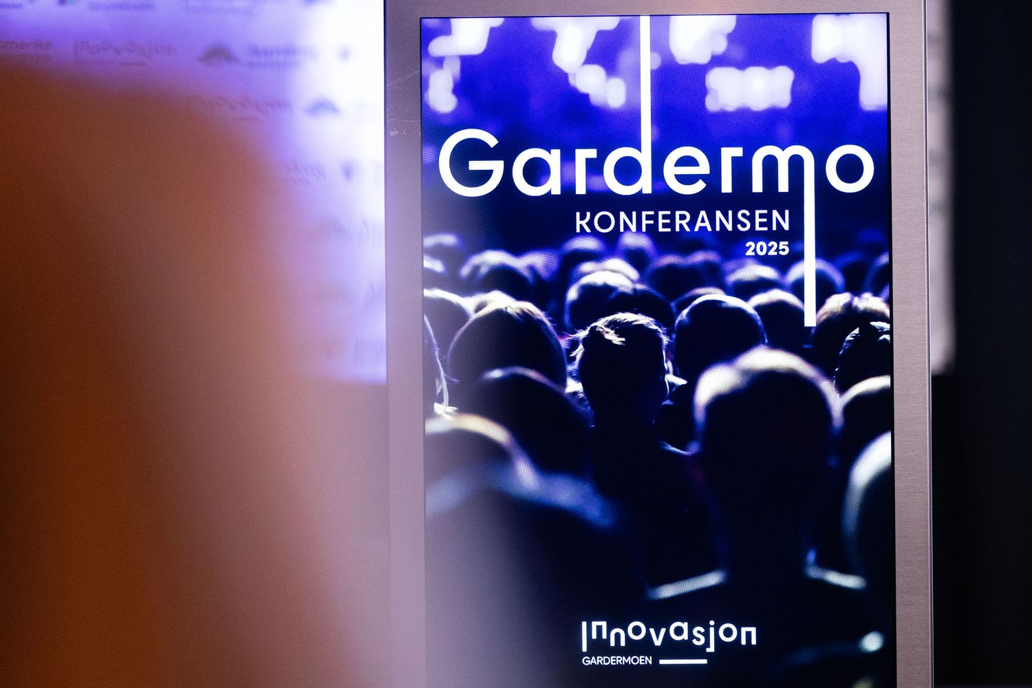 Illuminated digital sign displaying Gardermo Konferansen 2025 Innovasjon at a business conference.