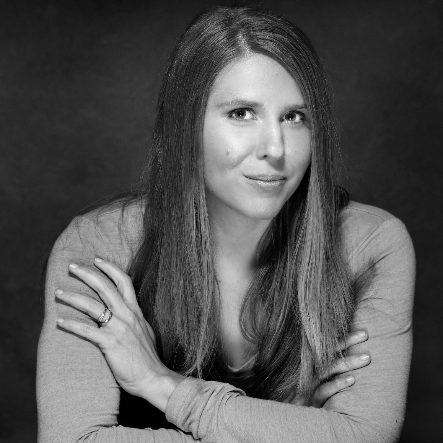 Black and white portrait series showing a person with long hair in various relaxed poses against a dark background.