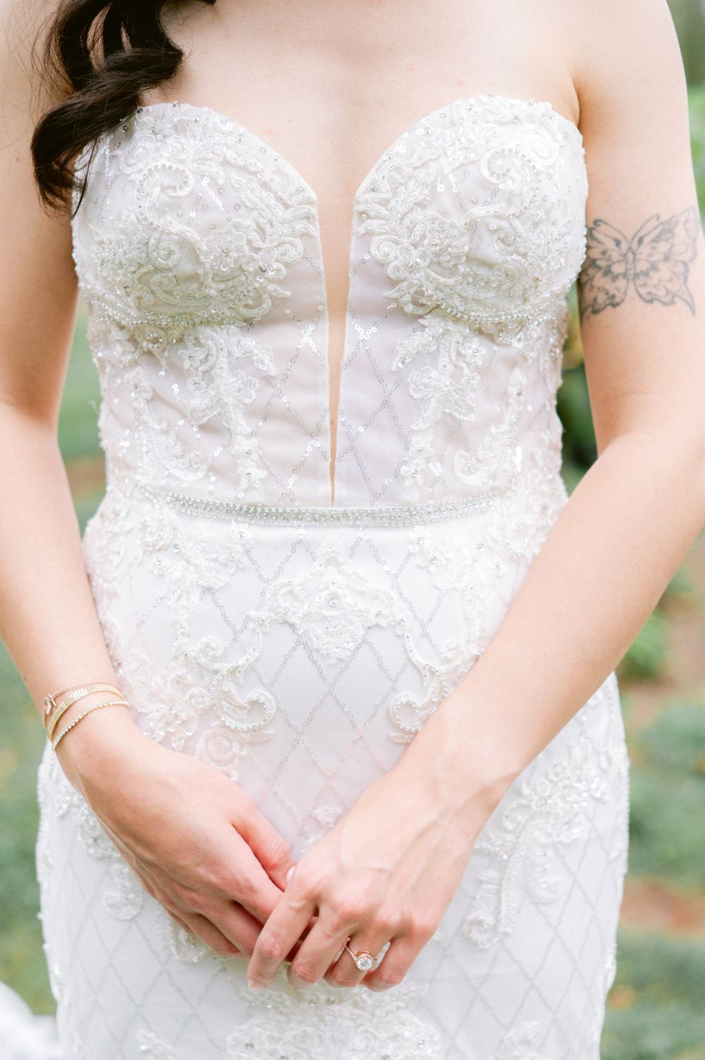 Close-up details of delicate white lace and beading on a strapless wedding dress bodice.