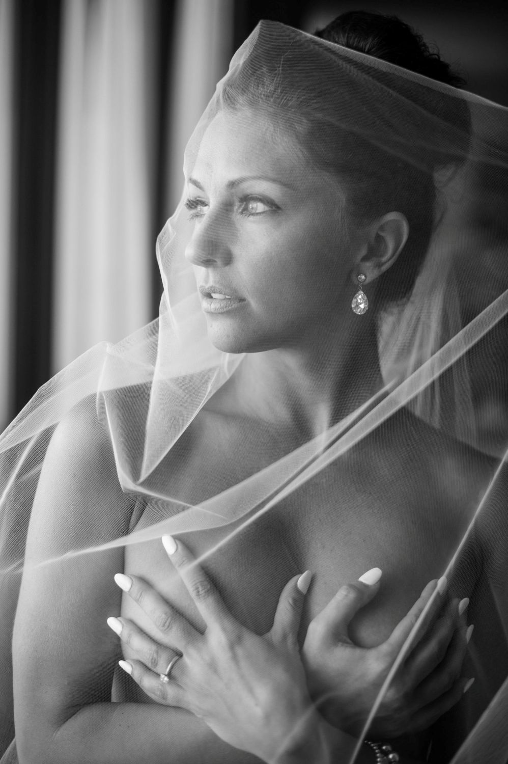 A black and white photo series shows a bride in her veil looking to the side in different poses.