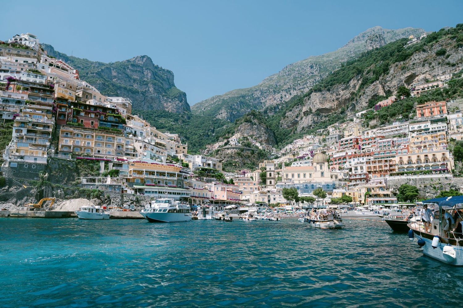 Panoramic view of colorful buildings along the Amalfi Coast with mountains and Mediterranean Sea in Italy.