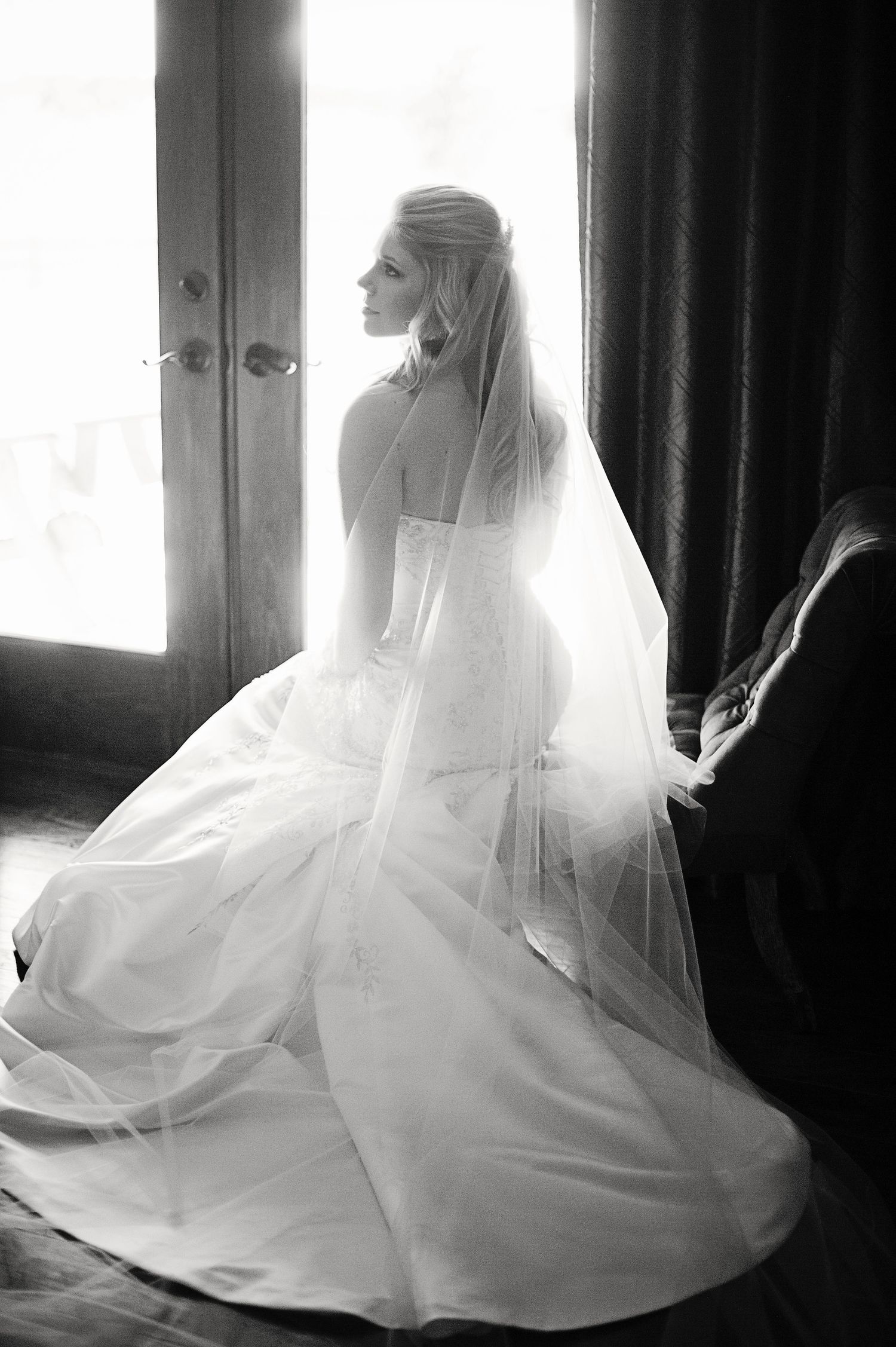 A series of artistic black and white photos showing a bride in a flowing white wedding dress and veil by a window.