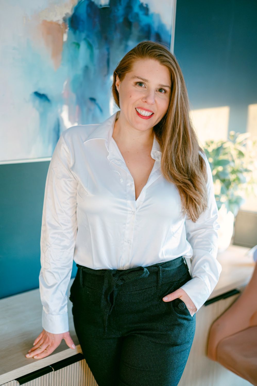 Professional headshots in a white button-down shirt and dark pants against a blue-tinted background.