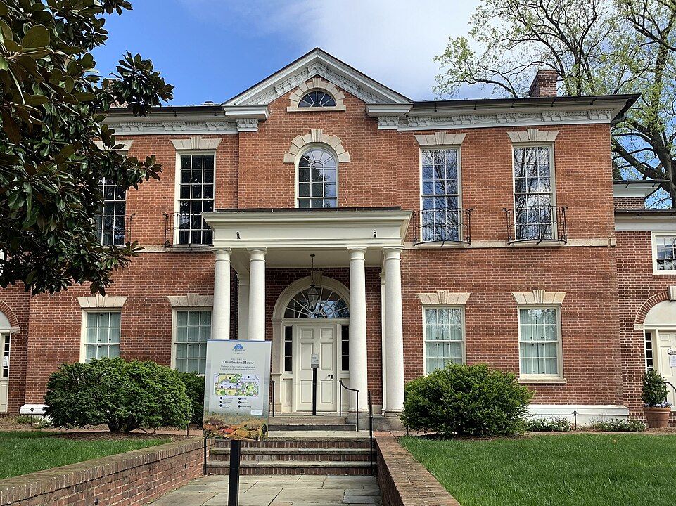 Historic red brick building with Greek Revival architectural features and white columns framing the entrance.