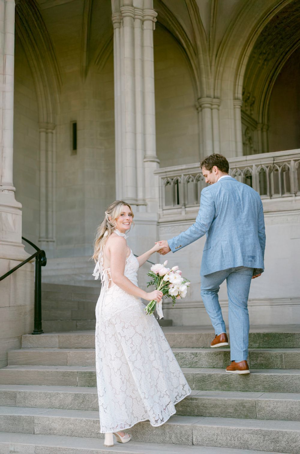 Bride and groom celebrating elopement on National Cathedral steps in Washington DC