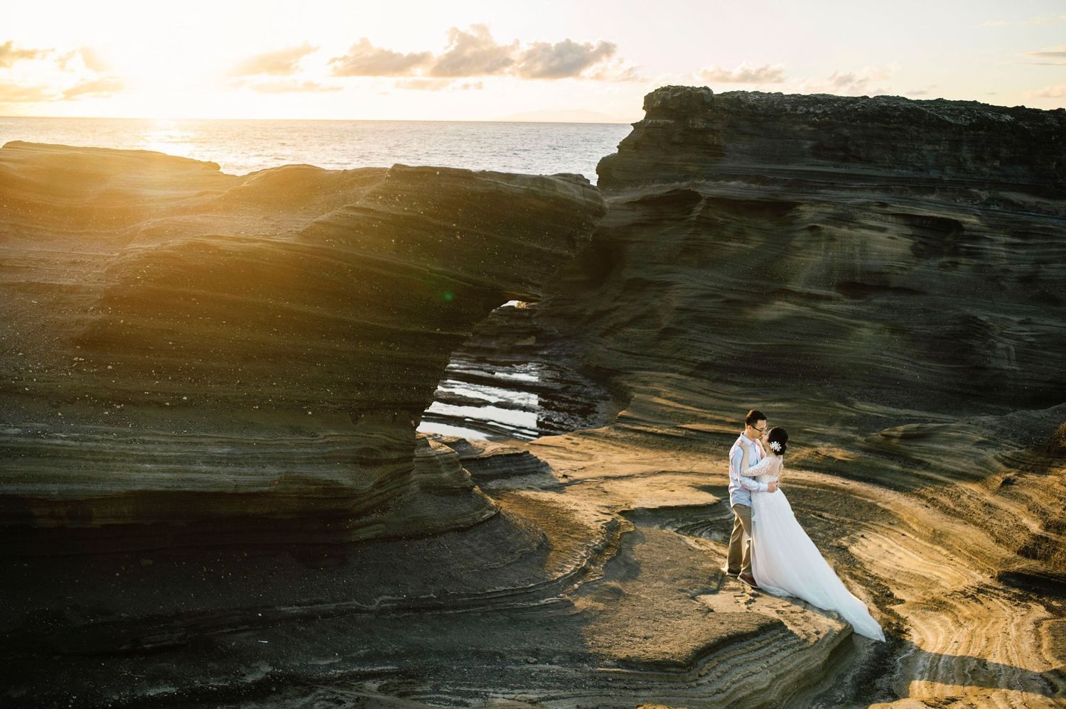 Scenic sunset view of rugged coastal cliffs and waves crashing against rocky shoreline at golden hour.