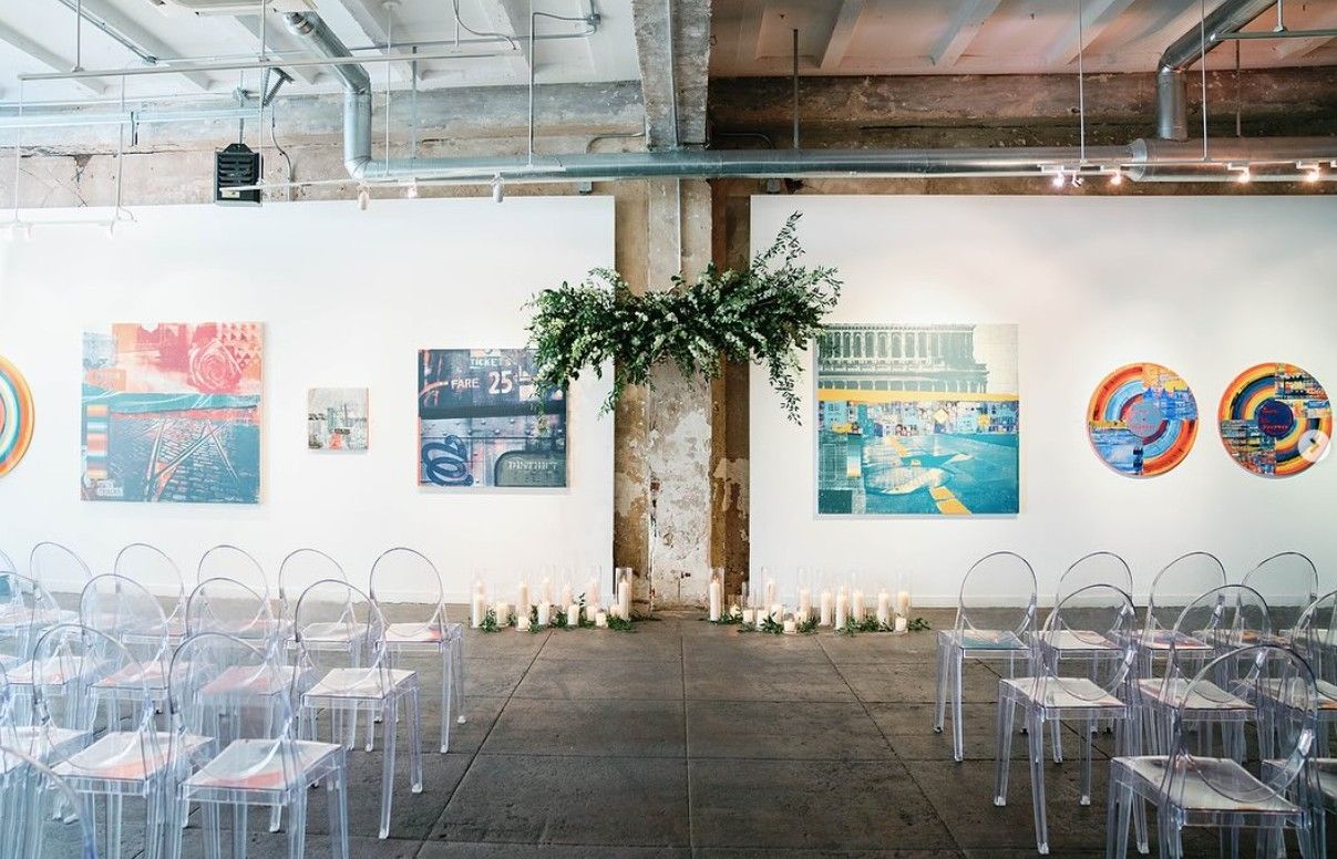 Wide panoramic view of an indoor workspace with NASA posters and memorabilia displayed on white walls.