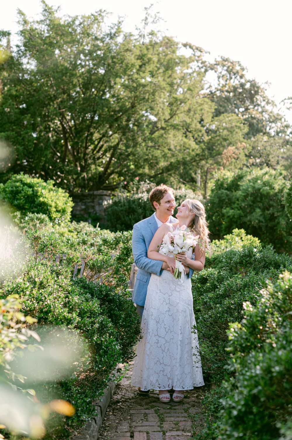 Bride and groom walking through Bishop's Garden stone pathways after elopement