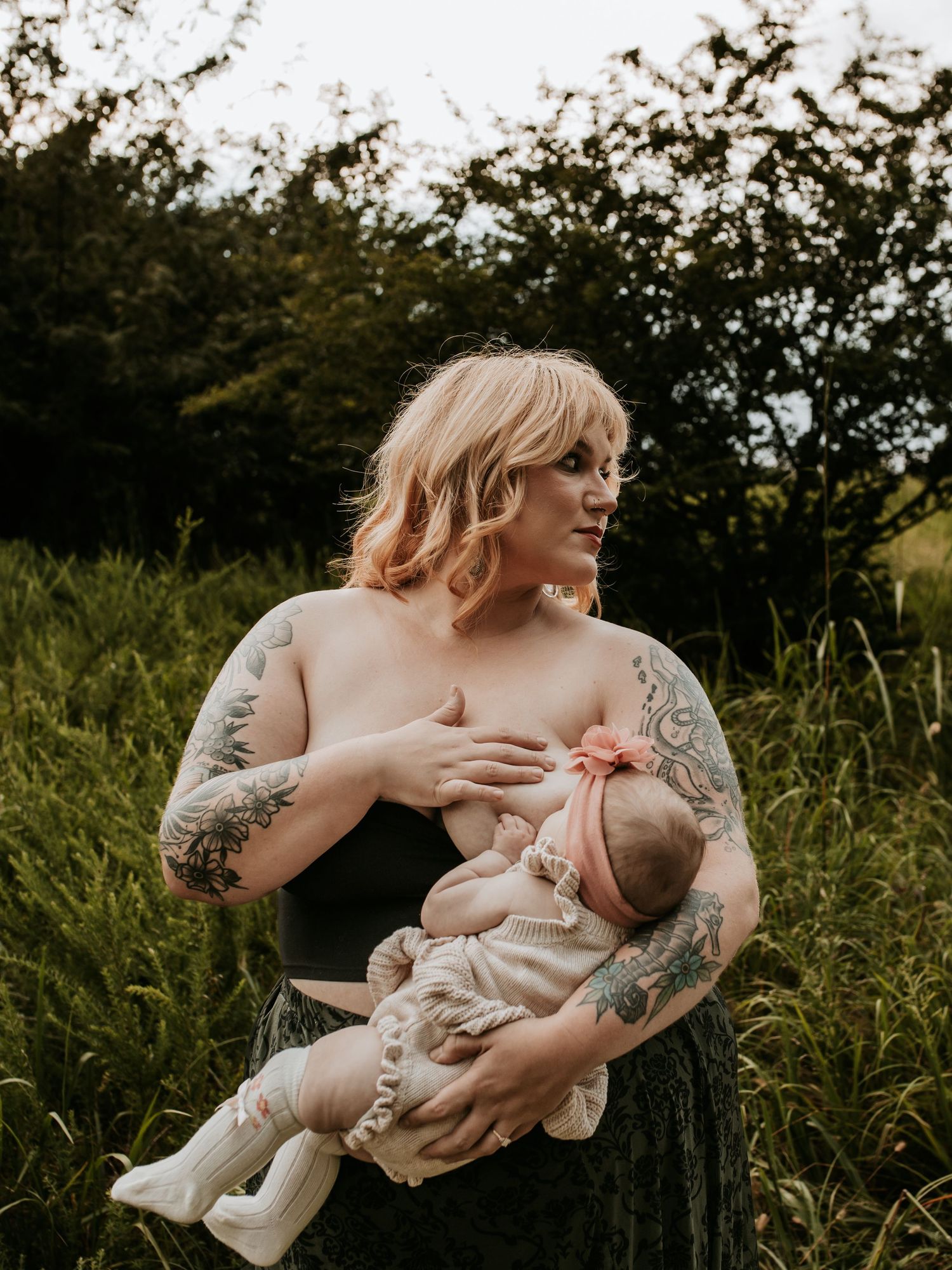 Mothers confidence shines bright while baby is breastfeeding in an Oklahoma field during golden hour with Keely King Photography