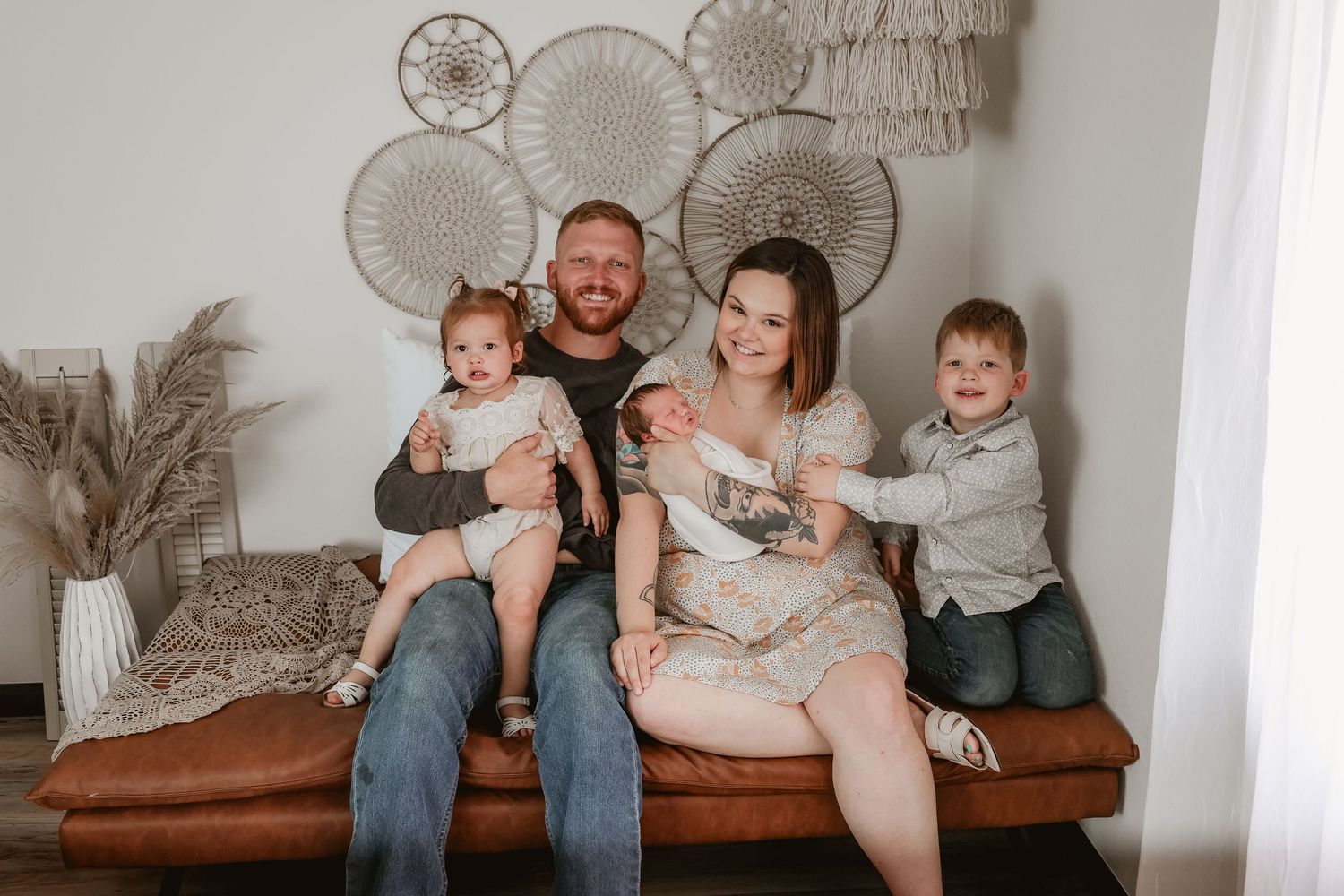 Family of five posing for a family newborn photography session in a studio.