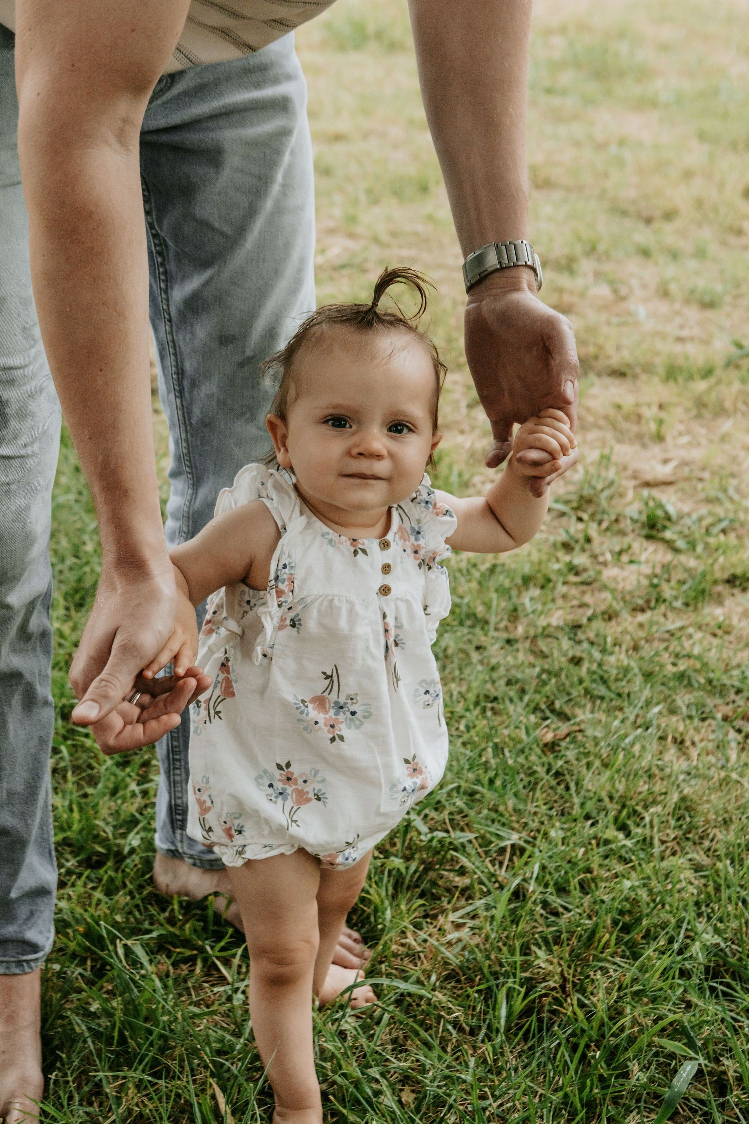 Father bent down to help toddler girl walk through Coal Creek Farm's pasture with Keely King Photography in Jenks Oklahoma