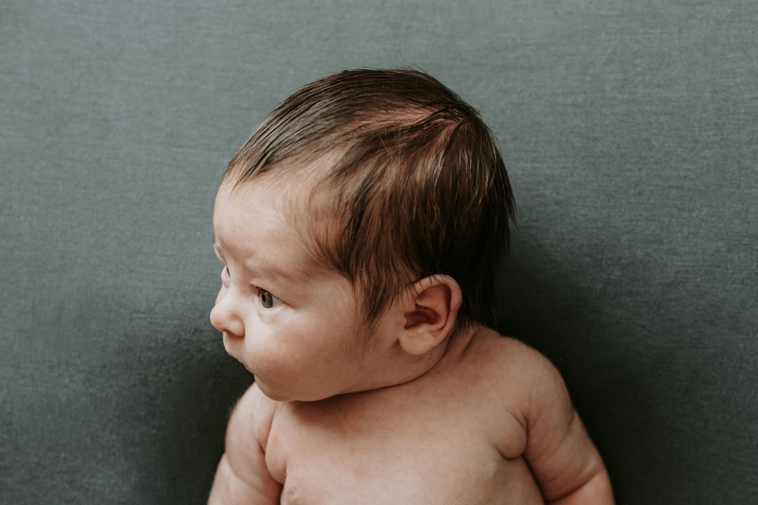 Keely King Photography takes a side profile photo of newborn boy showing all his newborn features from the chest up in Coweta Oklahoma