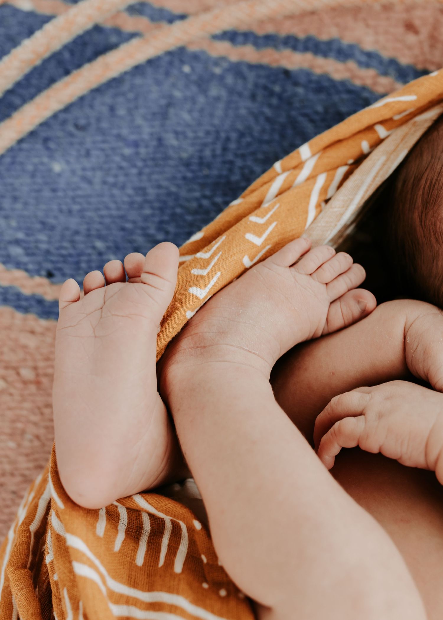 Close up of newborn baby feet wrapped in a western blanket on to of a horse blanket with a rope taken by Keely King Photography in Big Cabin