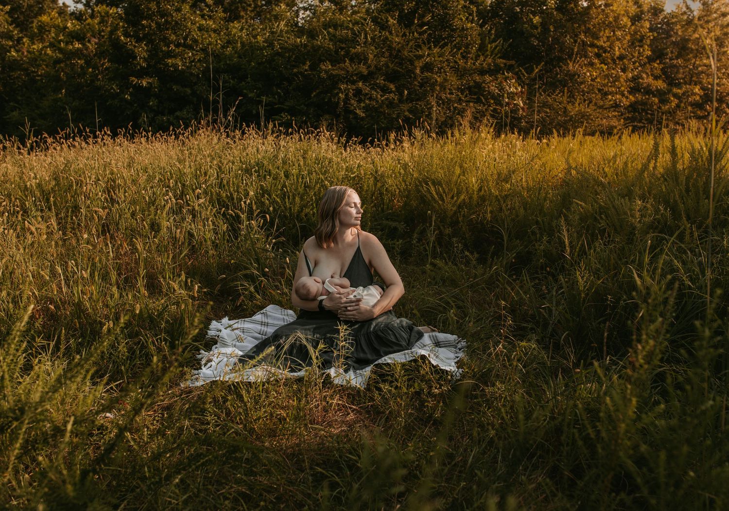 Keely King Photography documents Breastfeeding mother sitting in a Claremore Oklahoma field during golden hour.
