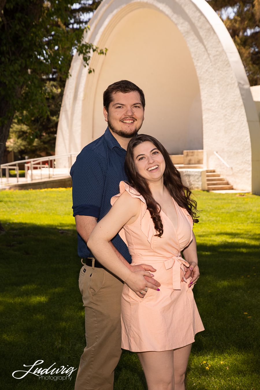 Engagement photo of a couple in Washington Park, Laramie, Wyoming. The band shell is shown in the background.