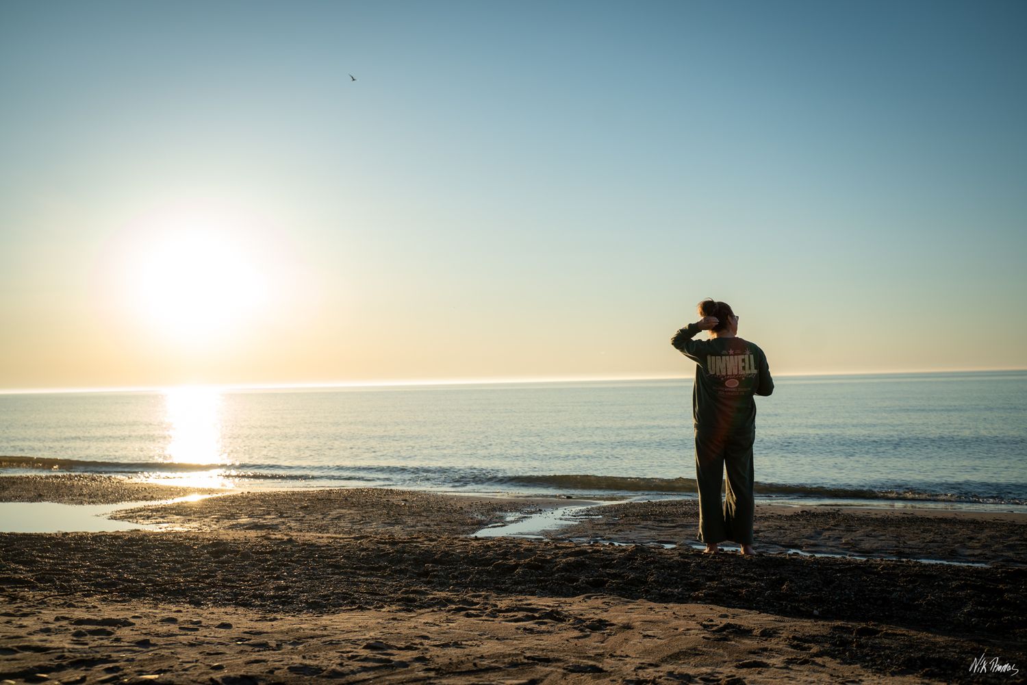 Lady standing at the edge of the water at the beach