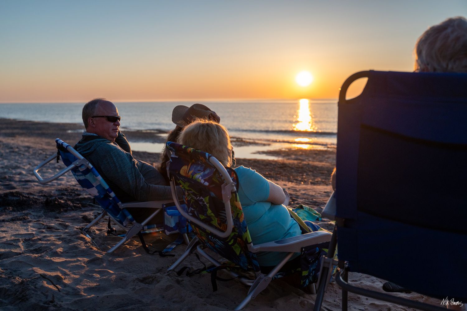 group watching sunset on beach