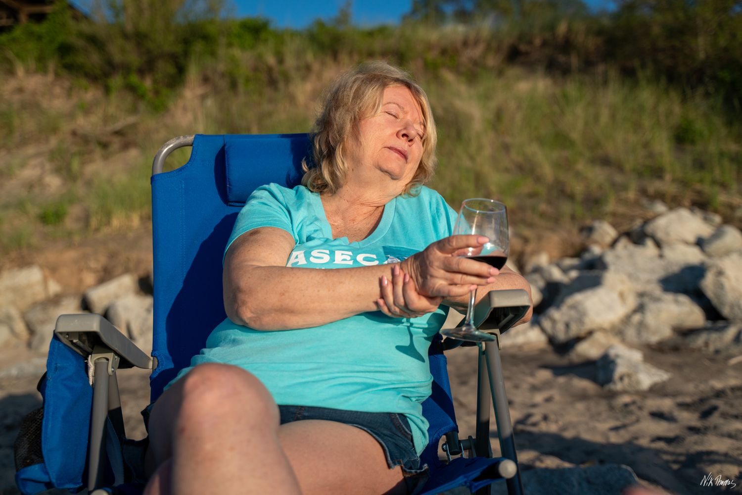 Lady laughing while sitting in a chair at the beach