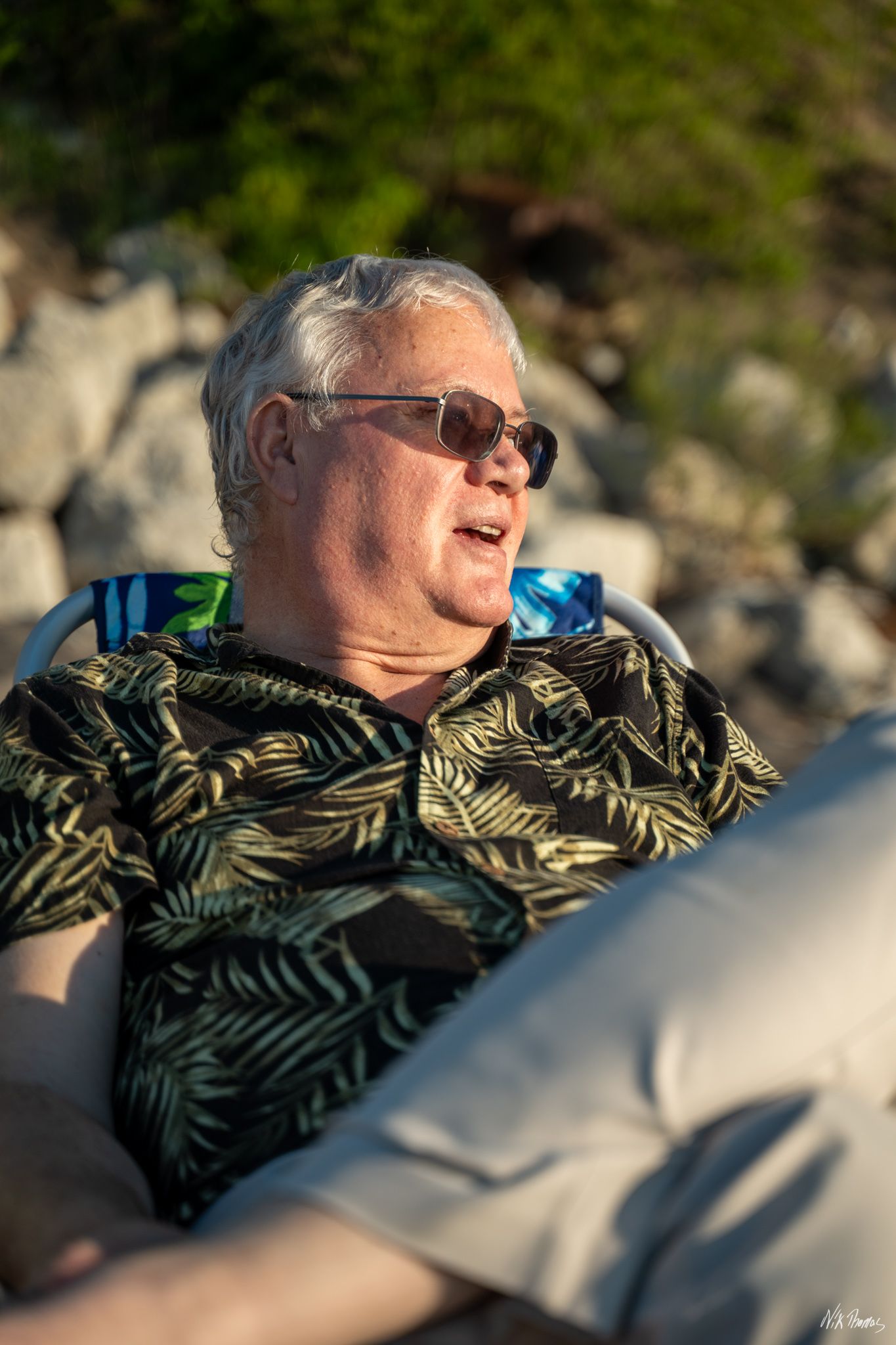 man sitting in a chair at the beach