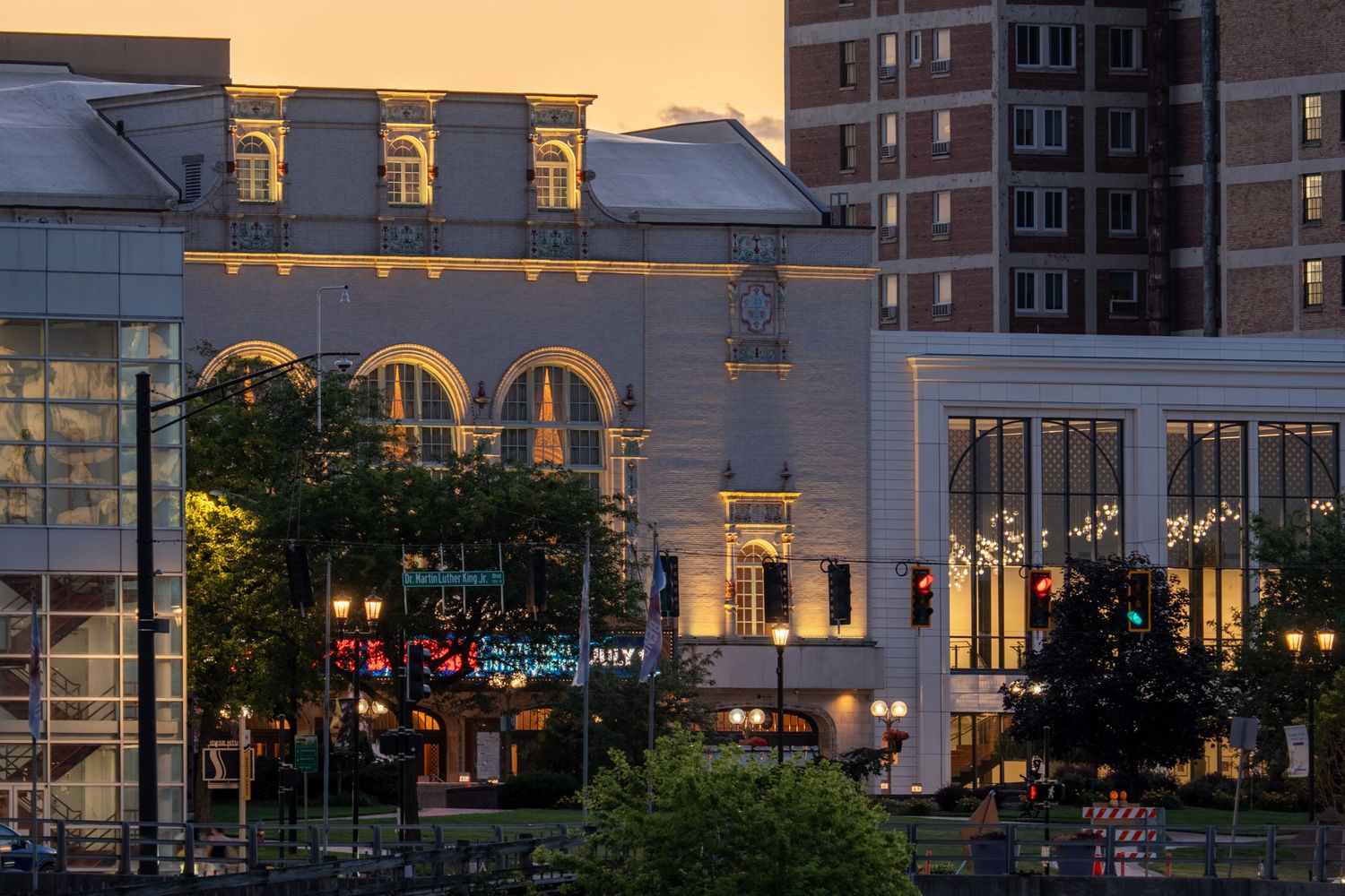 Historic downtown building illuminated at dusk with city lights and traffic signals glowing in the evening sky.