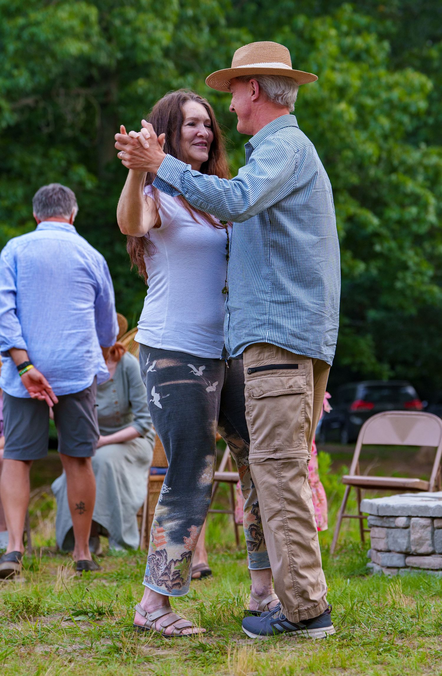 Couple dancing together on grass at an outdoor summer cultural festival event.
