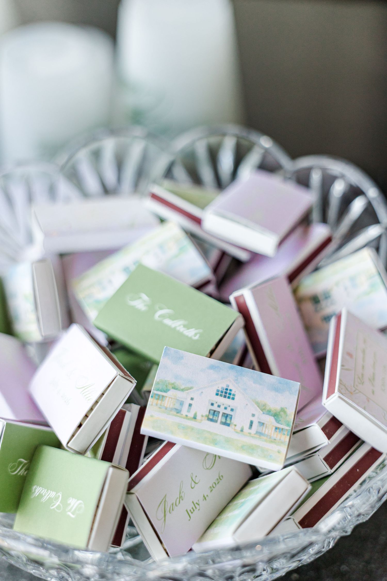 Custom wedding matchboxes with illustrated venue and couple's names displayed in a crystal bowl.