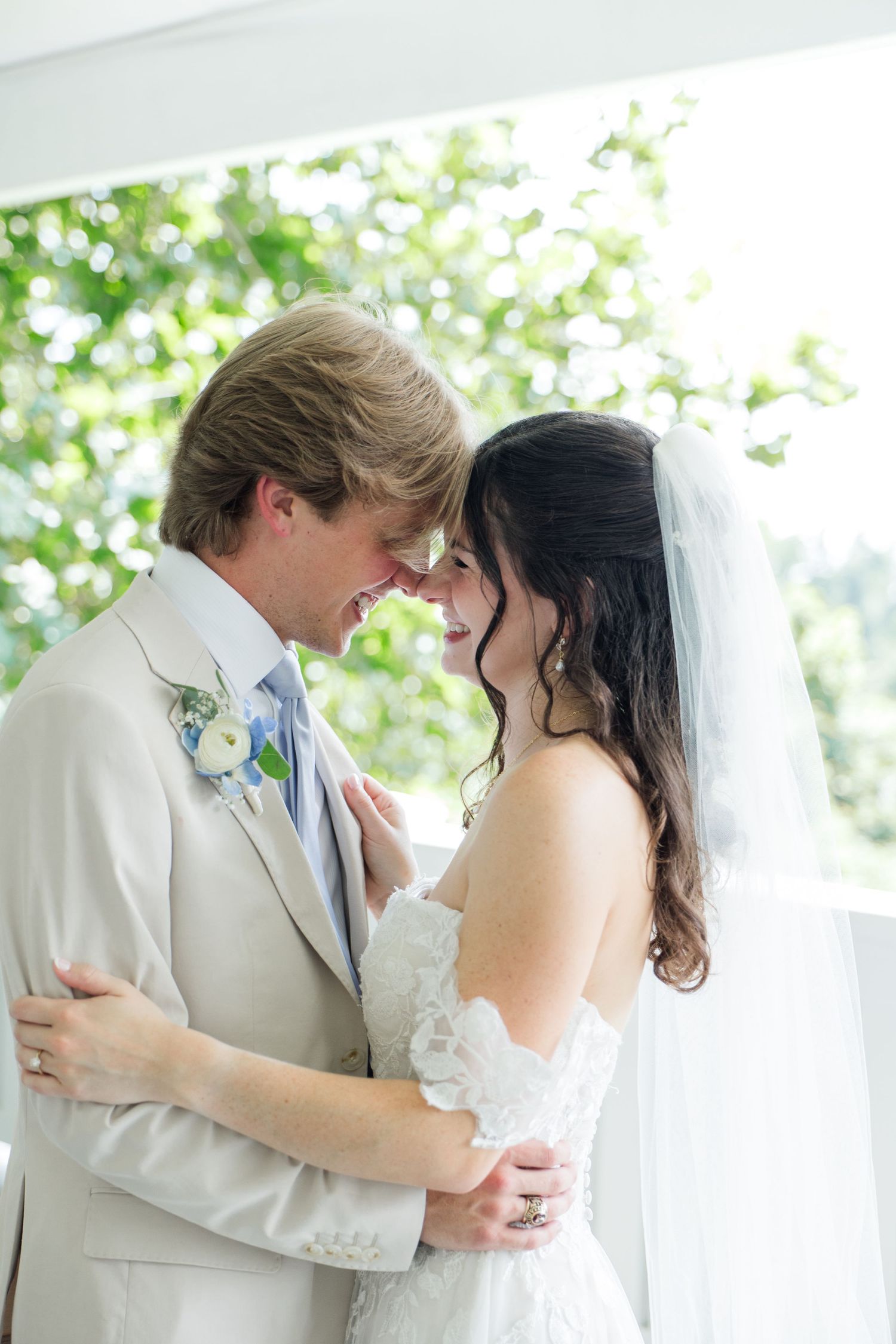 Bride and groom touch foreheads tenderly in an intimate embrace during their wedding first look moment.