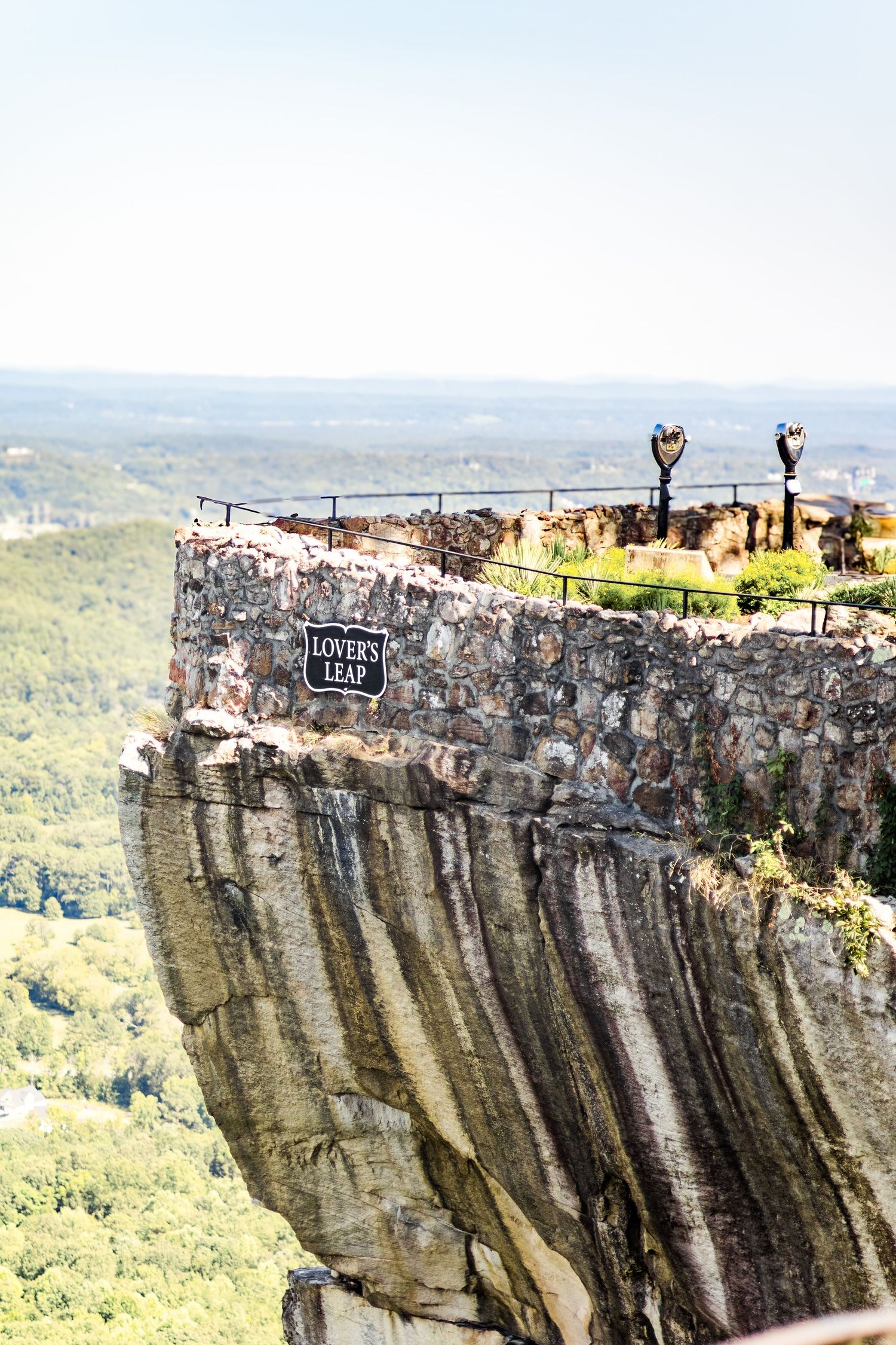 Lovers Leap overlook at Rock City with panoramic views of green valleys below on a sunny day.