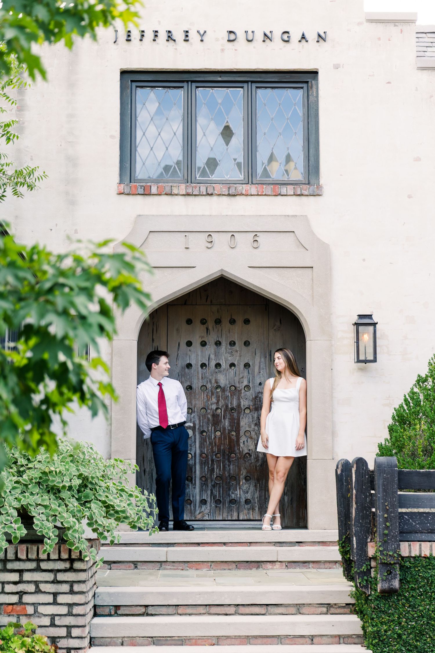 A couple stands in a grand arched doorway of the historic 1906 Jeffrey Dungan building.