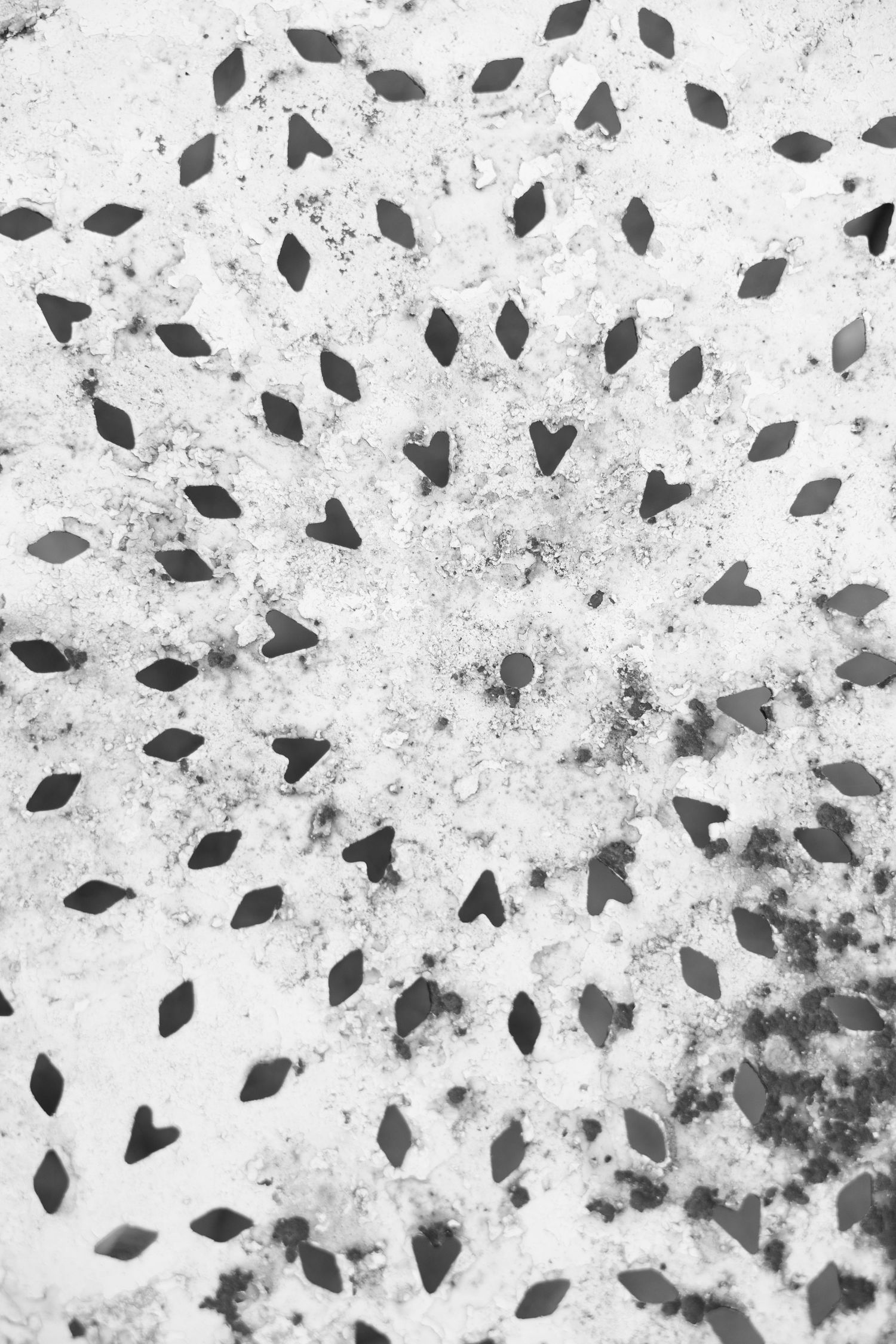 Black and white abstract pattern with diamond and heart shapes scattered on a textured grunge background.