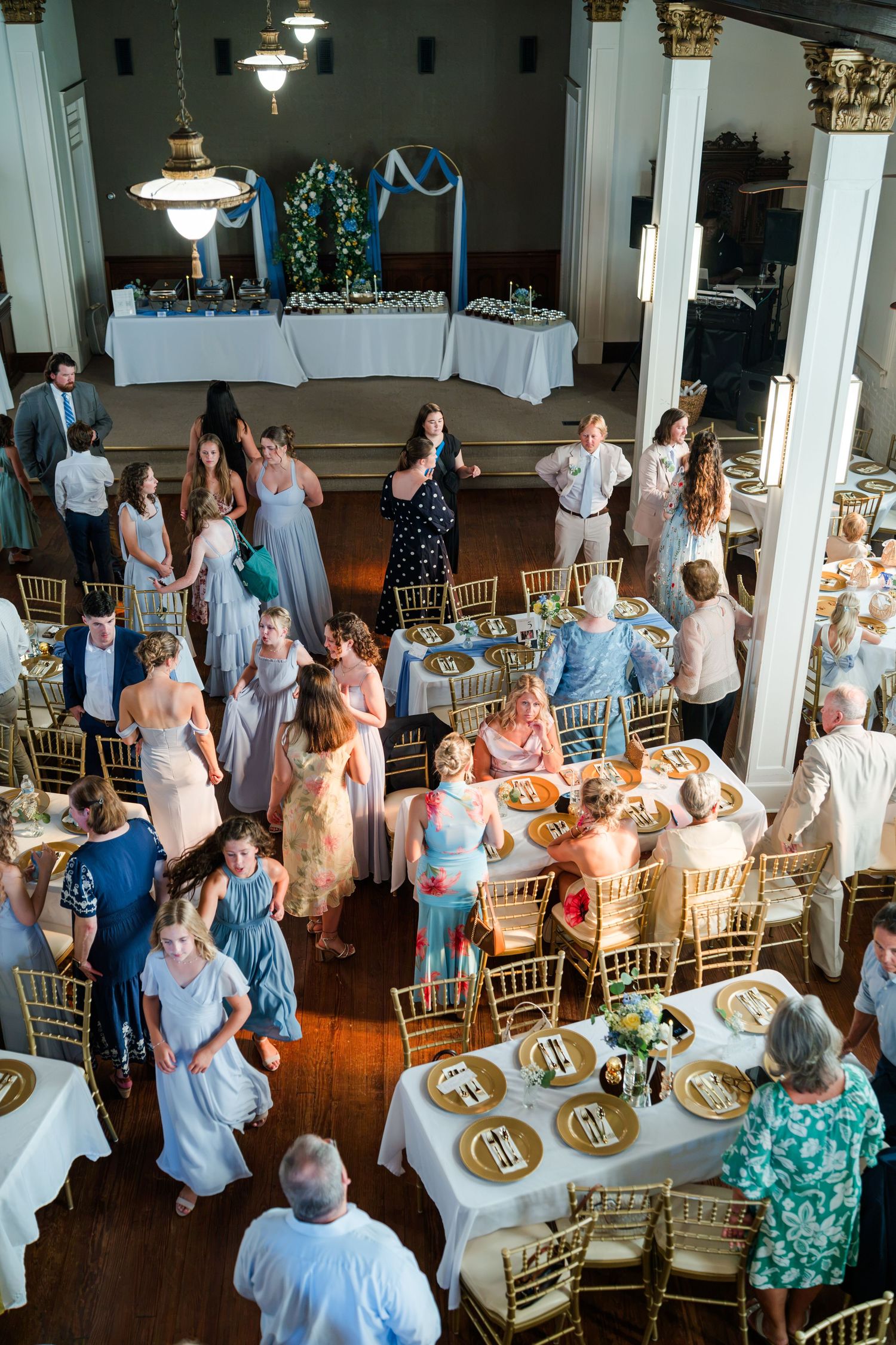 Aerial view of elegant wedding reception hall with gold chiavari chairs and round tables.