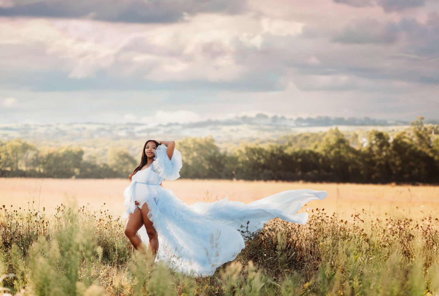 A flowing white dress billows in the breeze as someone poses gracefully in a sunlit meadow at golden hour at Prophettown State Park