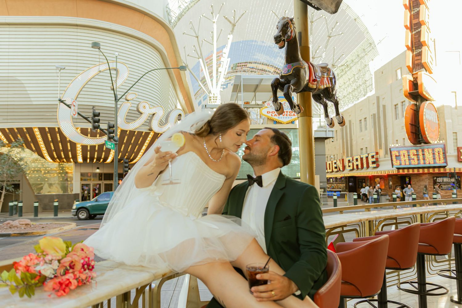 Bride and groom sharing a romantic moment on a carousel at Fremont Street in Las Vegas on their wedding day.