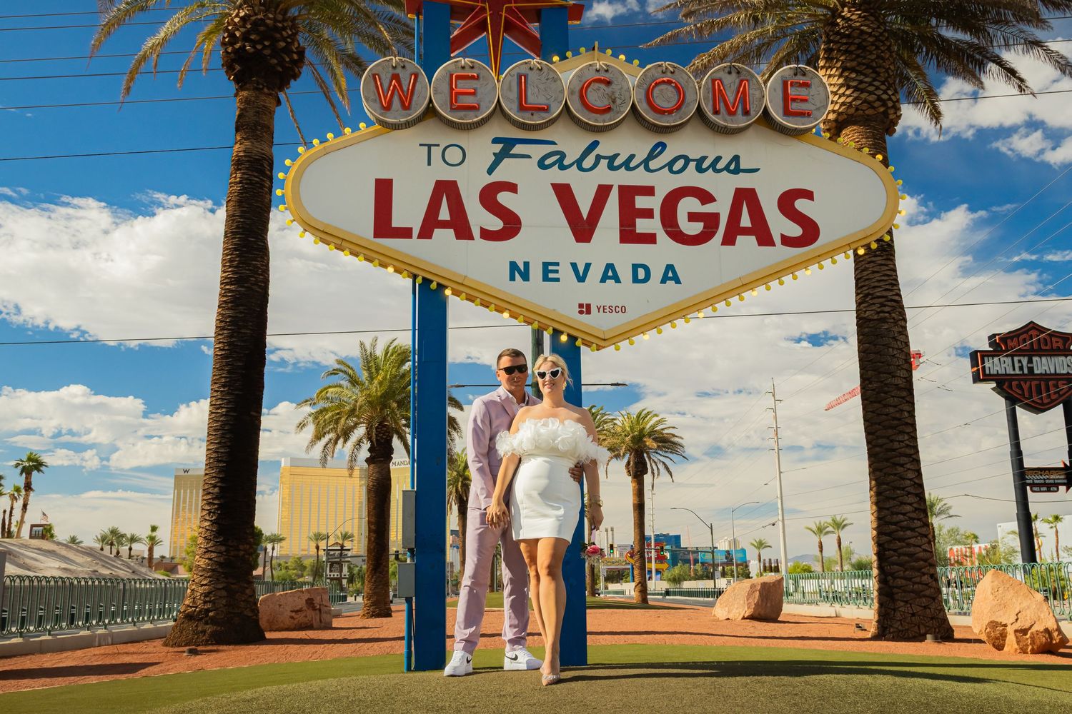 Newlyweds posing together under the iconic Welcome to Fabulous Las Vegas Nevada sign.