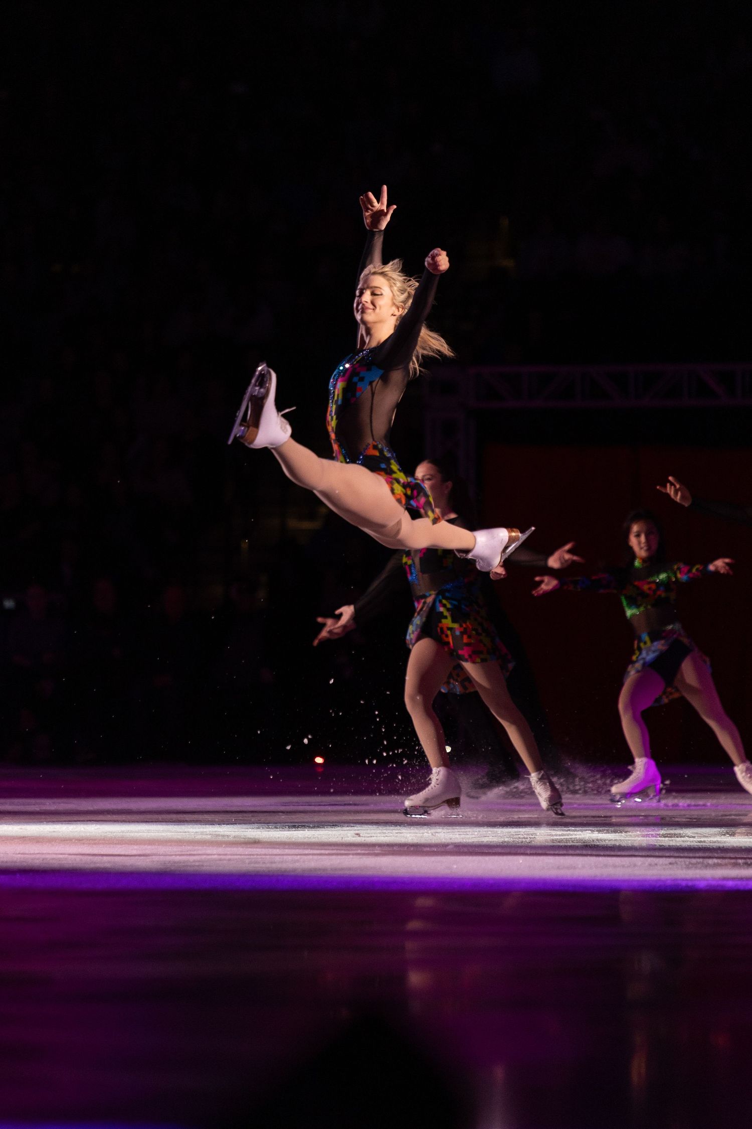 Amber Glenn, figure skater, preforming a split jump.
