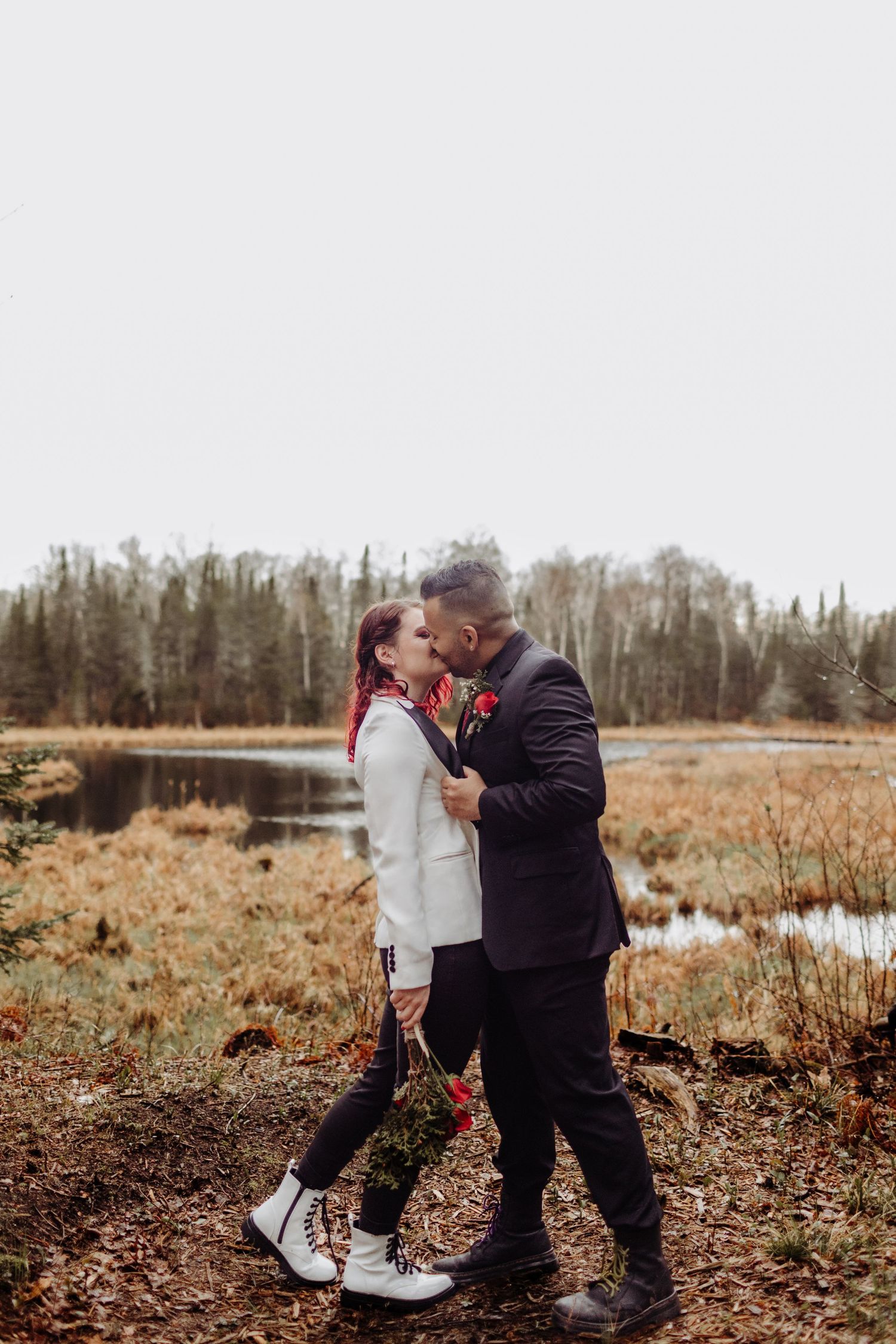Bride and Groom kissing on a hill in front of a watershed area.