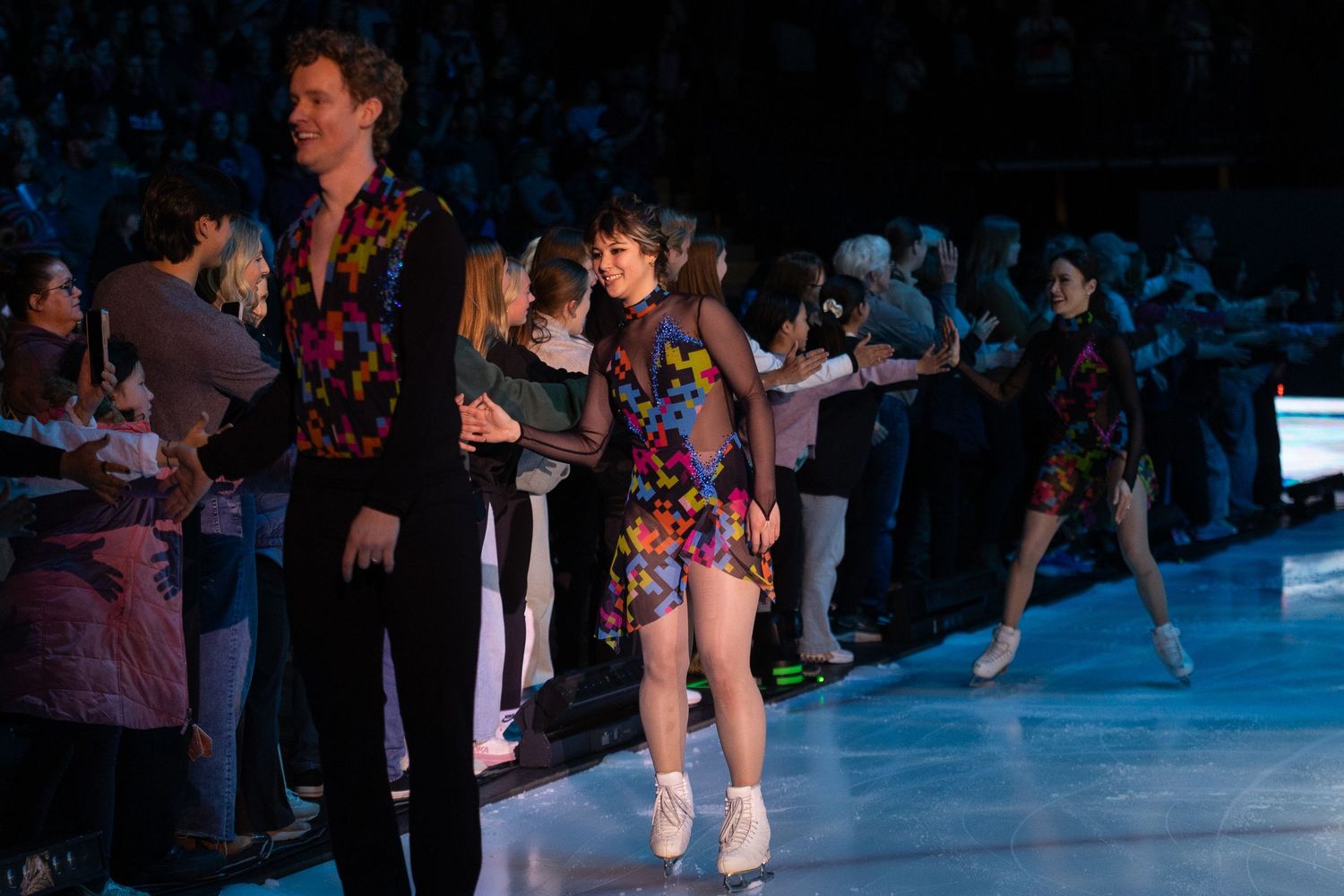 Alysa Liu, figure skater, meeting spectators on the side of the ice and giving high fives.