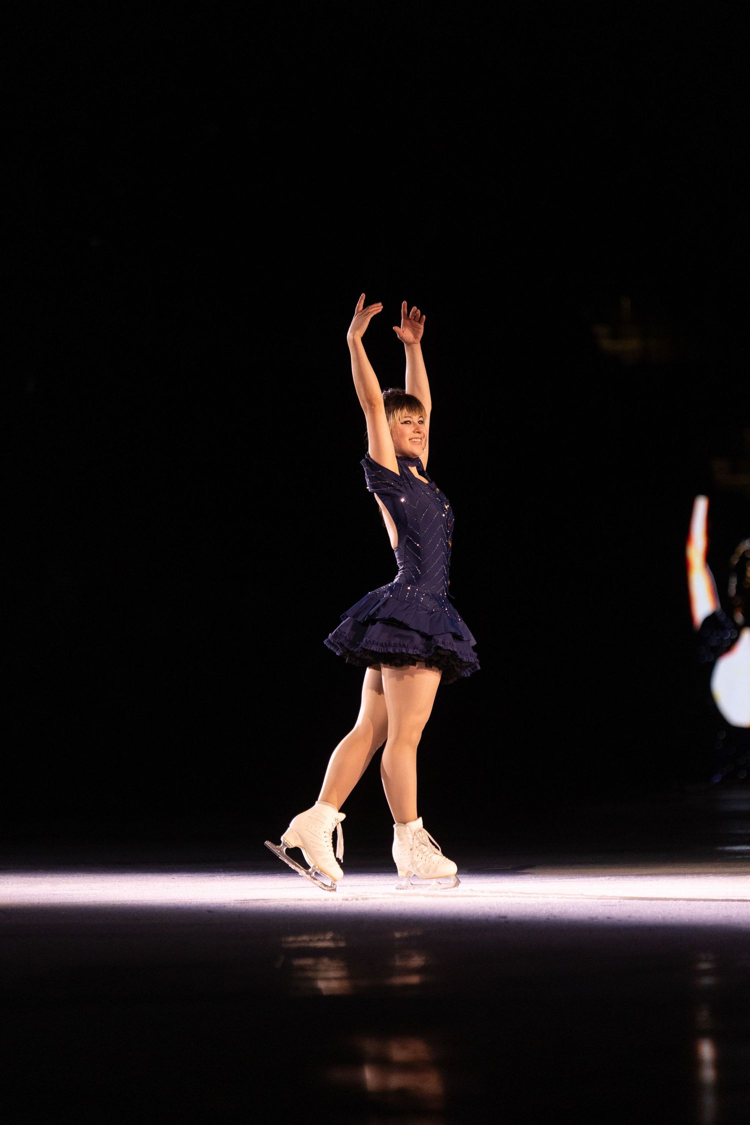 Alysa Liu figure skater, ending her Stateside program. Standing arms up after bowing to the crowd.