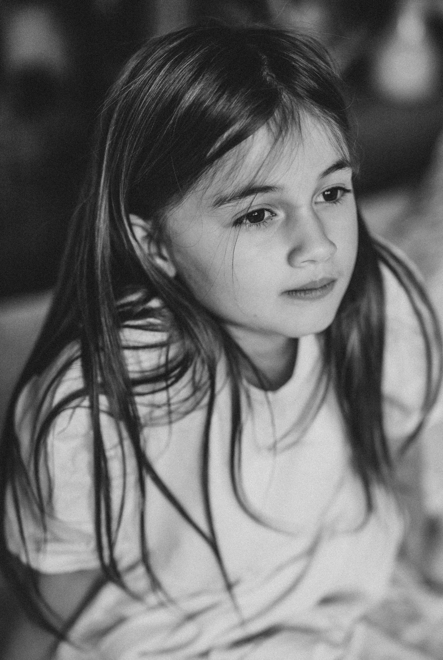 A black and white  portrait of a girl looking, documentary-style family photography capturing everyday life