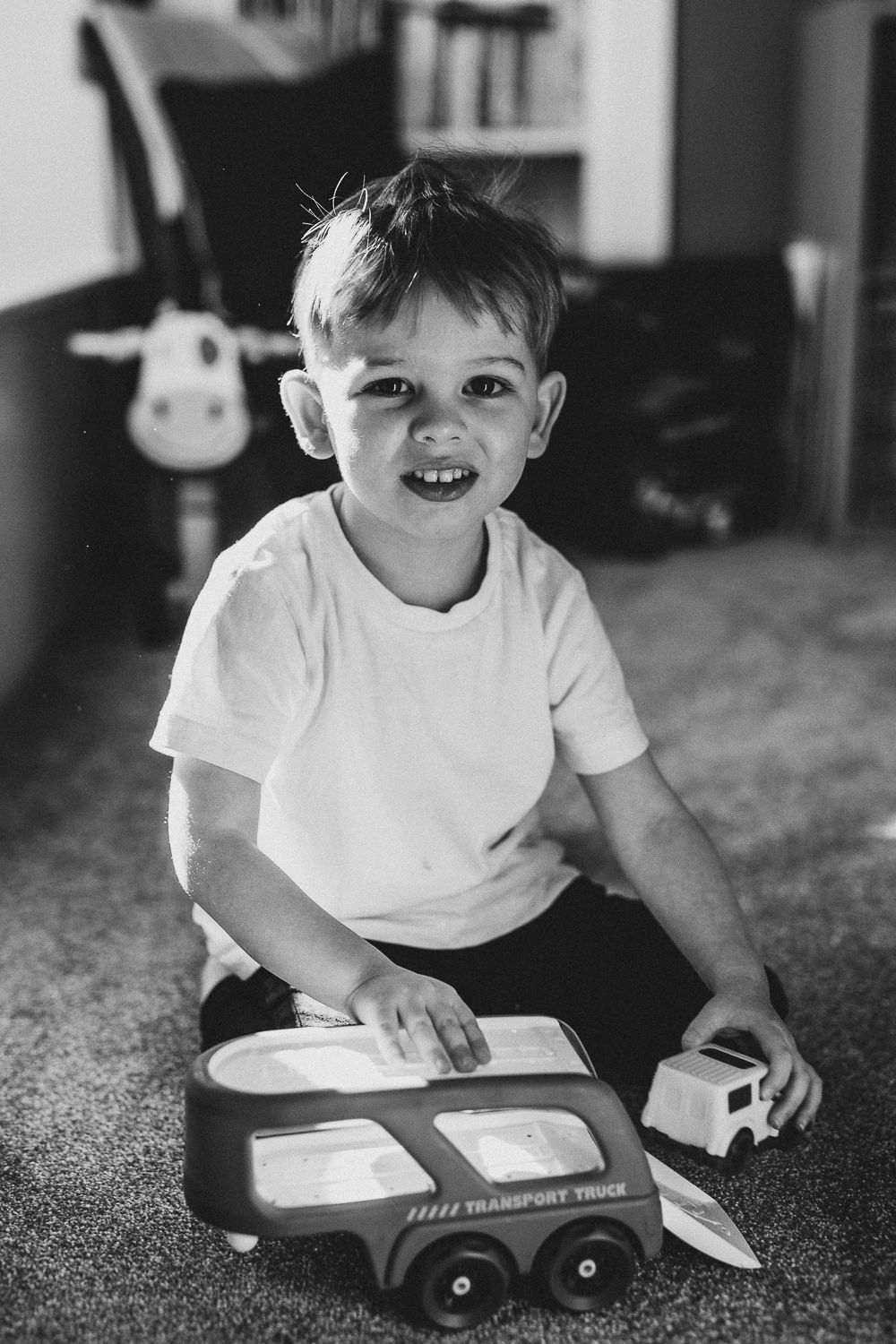 A boy playing with cars, documentary-style family photography capturing everyday life