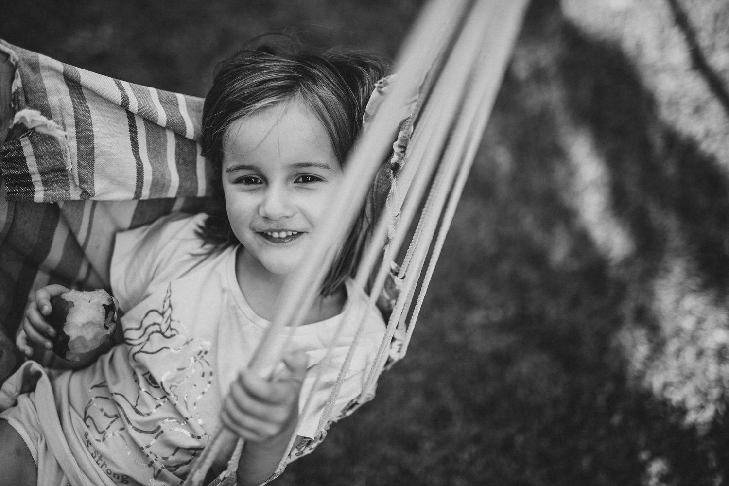 A child swinging on a hammock during natural family photography session outdoors
