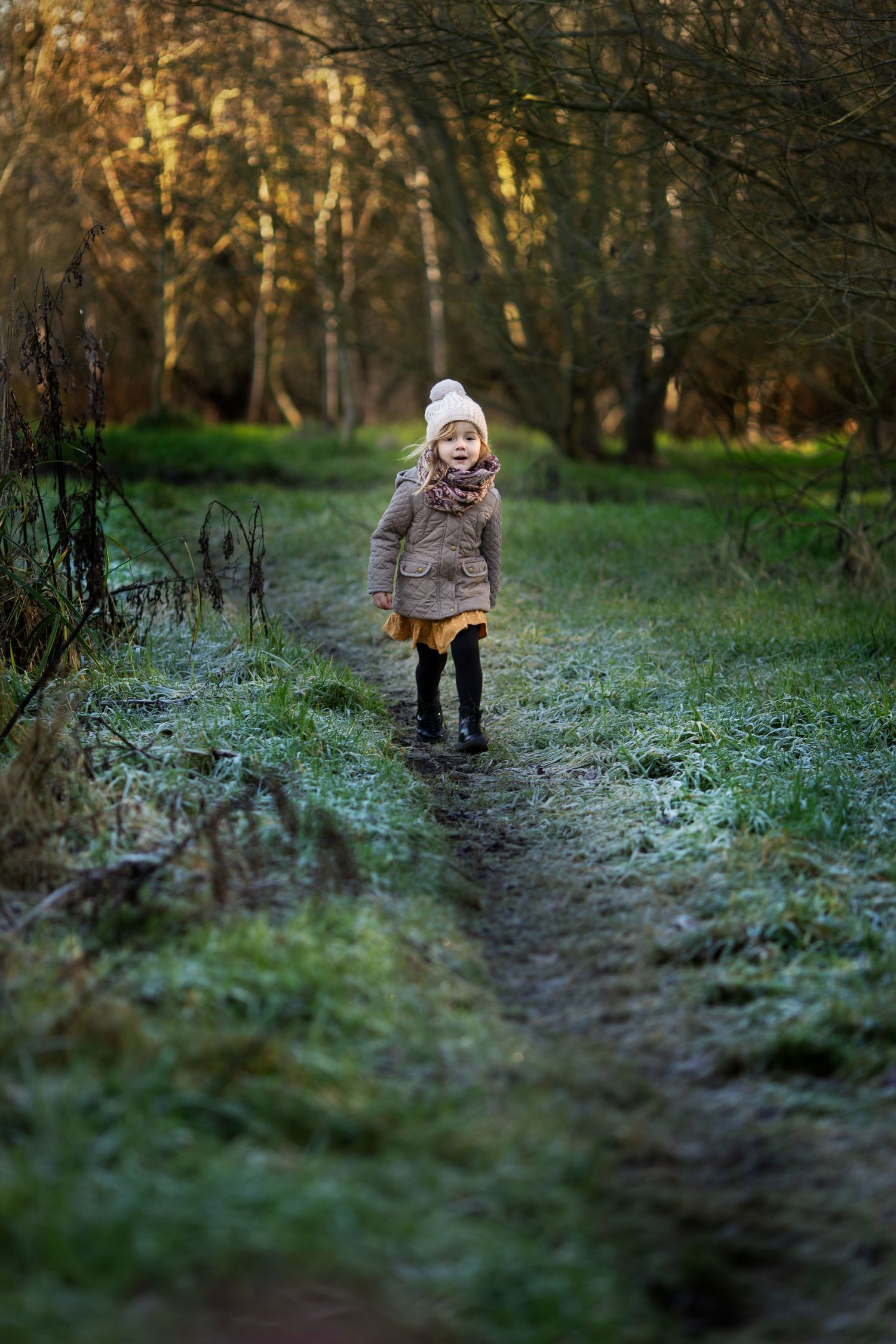 A girl running in a park during a family photoshoot outdoors in winter