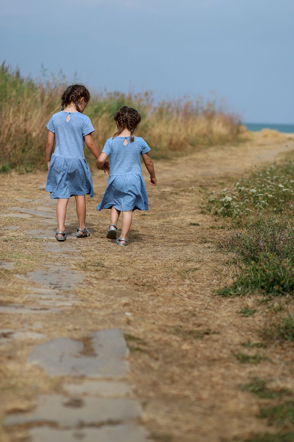 Children walking  towards the sea during natural family photography session