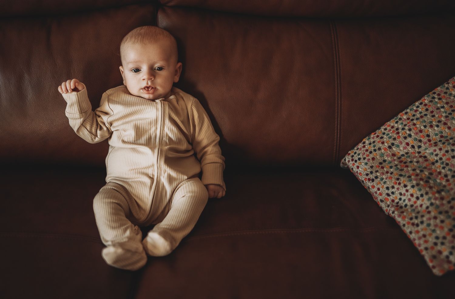 Baby on the sofa, documentary-style family photography capturing everyday life