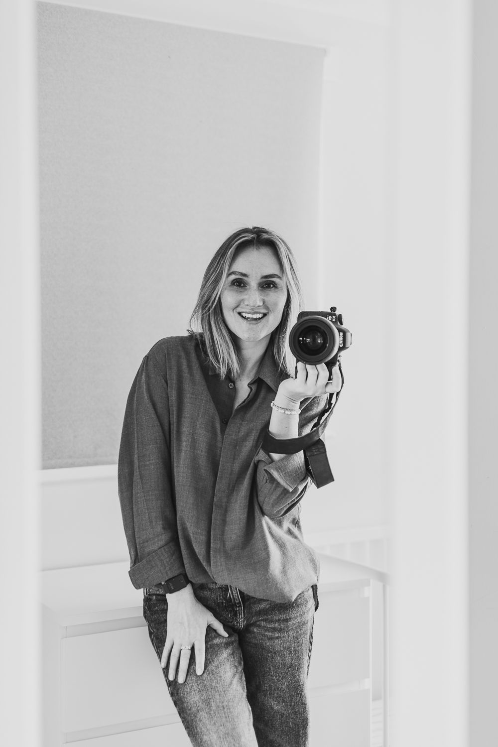 A photo of a smiling woman holding a camera. Sariya S Photography,  lifestyle family photography in Angus and Dundee