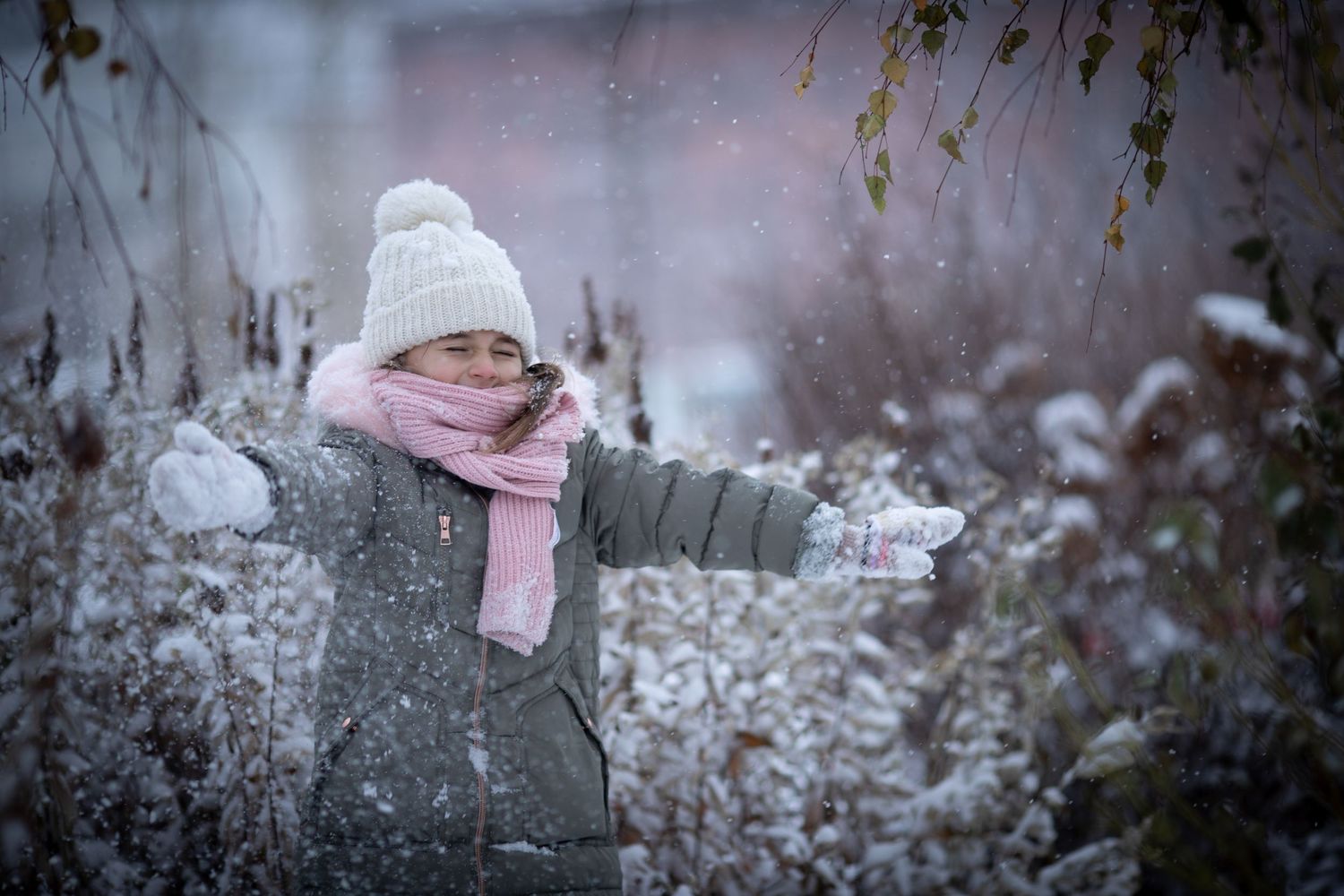 A child playing with snow during a family photoshoot outdoors in winter
