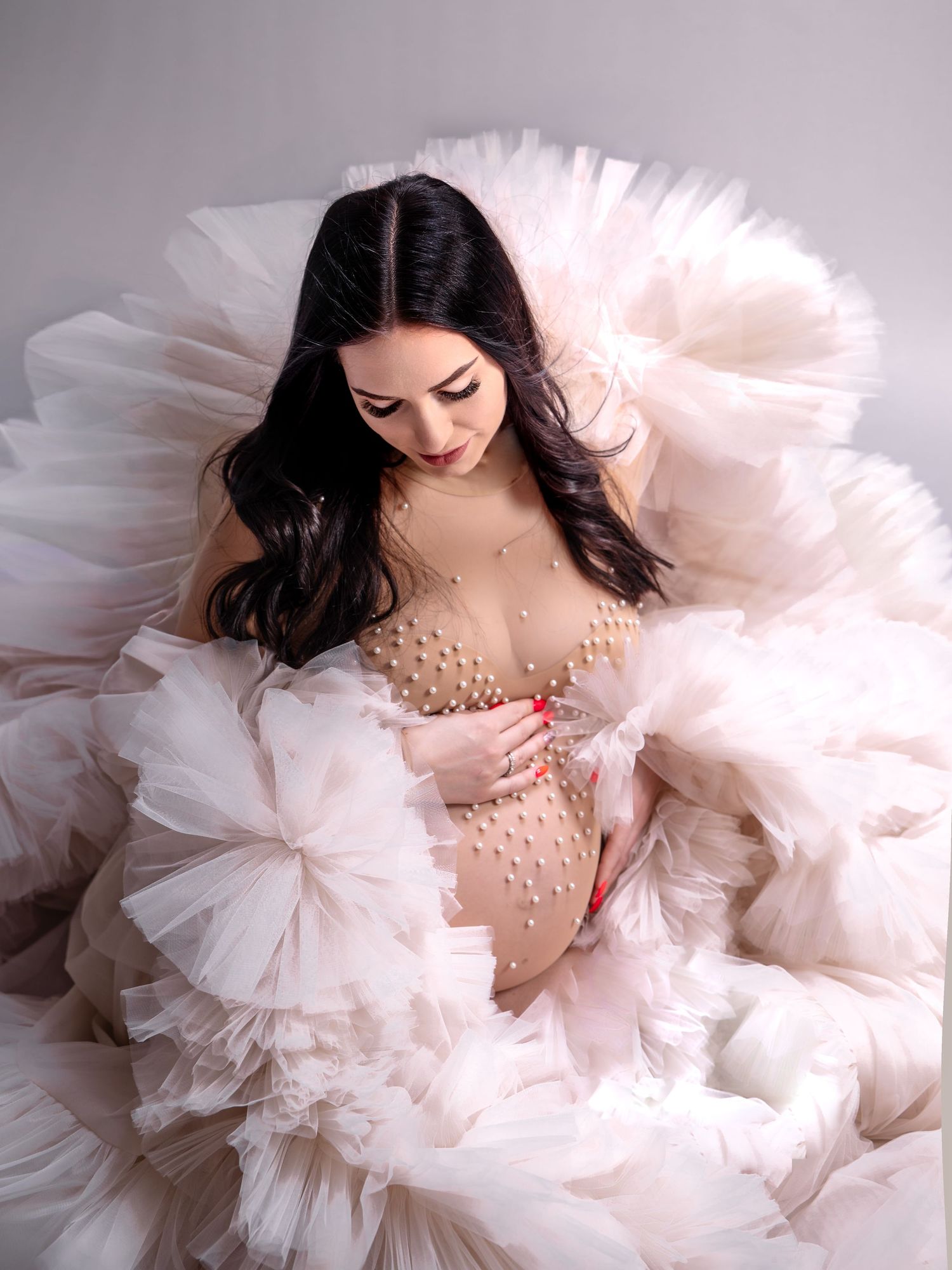 Schwangere Frau in weichem Tüll im Studio – zarte Babybauchfotografie in Nürnberg