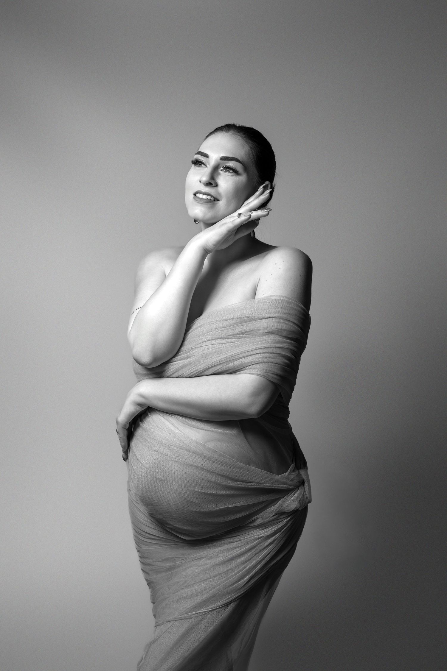 Schwangere Frau im rosa Kleid im Studio – elegante Babybauchfotografie in Nürnberg