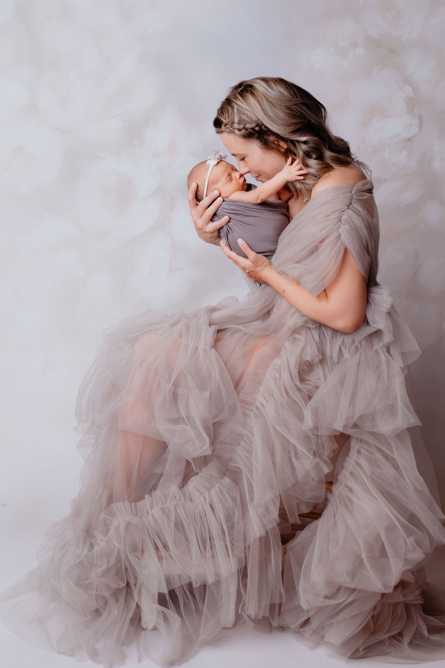 Frau sitzt mit Babybauch im Studio – natürliche Babybauchfotografie in Nürnberg