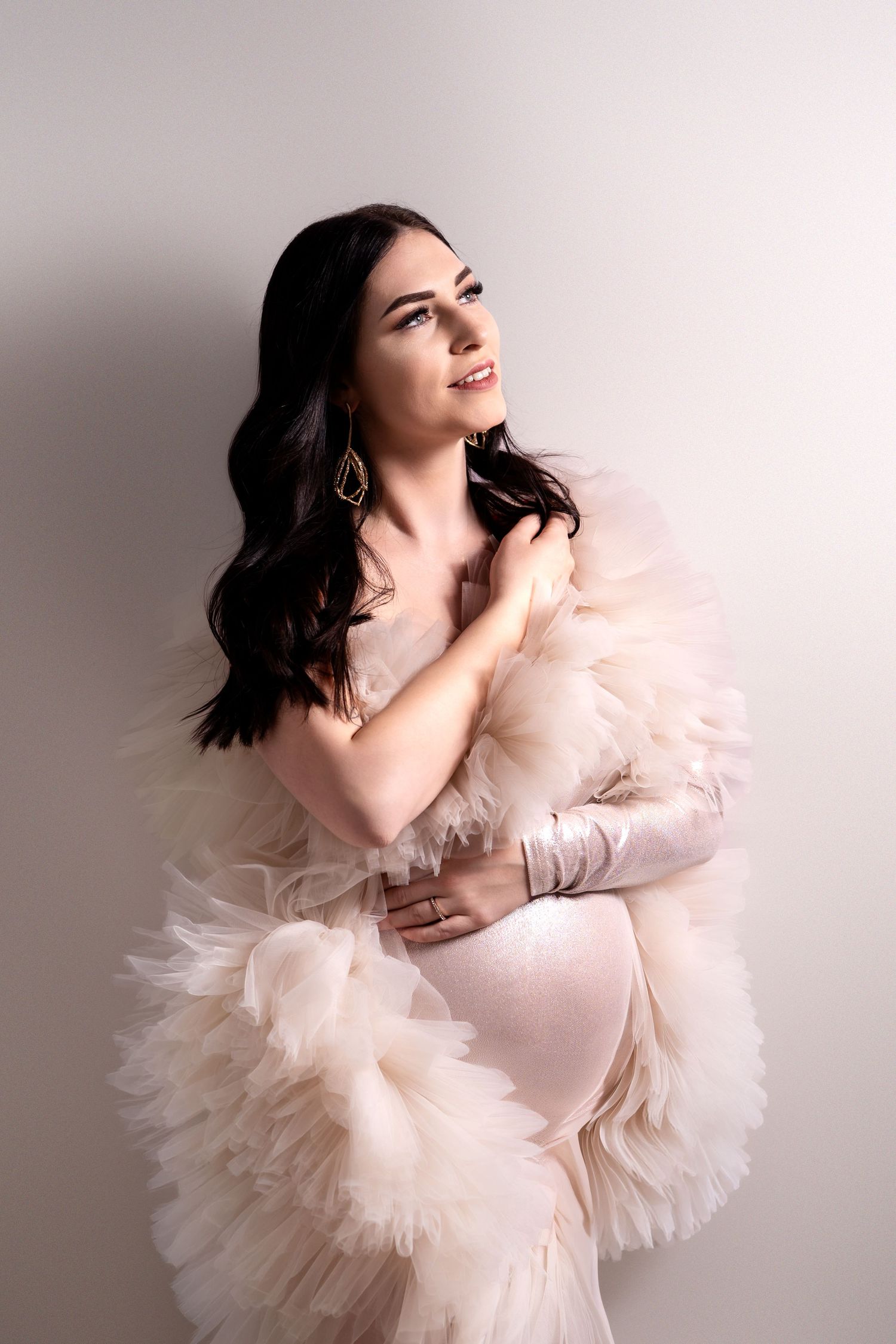 Schwangere Frau mit weichem Tüll im Studio – zarte Babybauchfotografie in Nürnberg